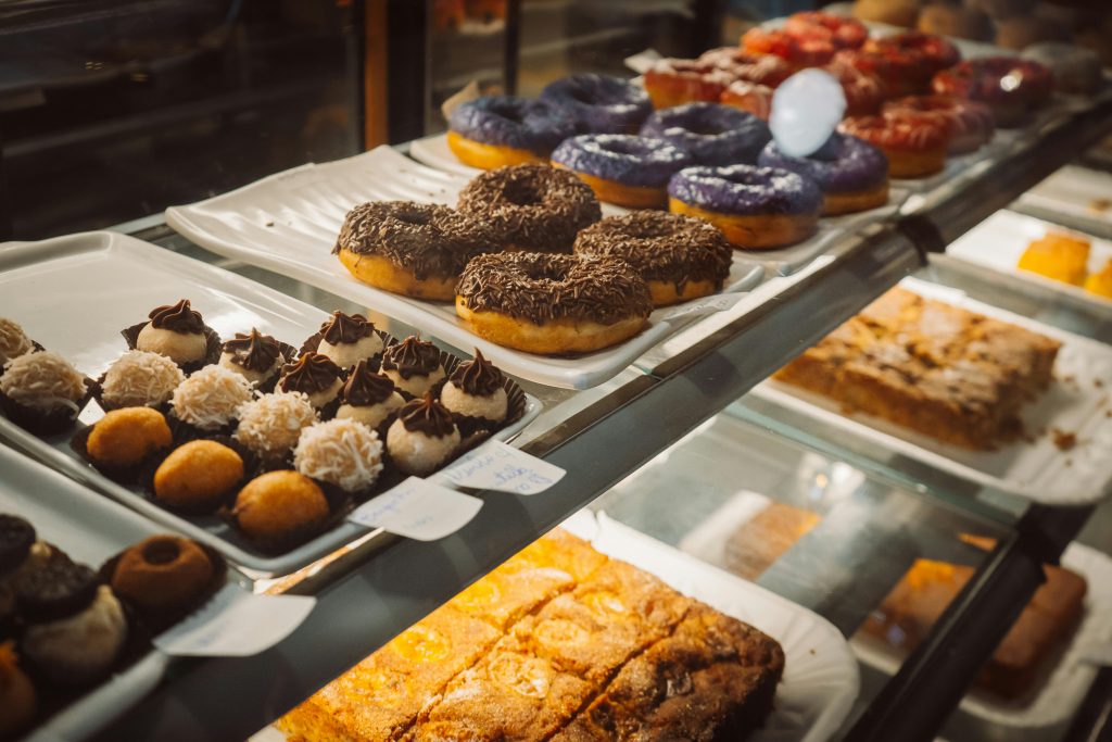A variety of colorful donuts and pastries on display in a bakery case, enticing and delicious.